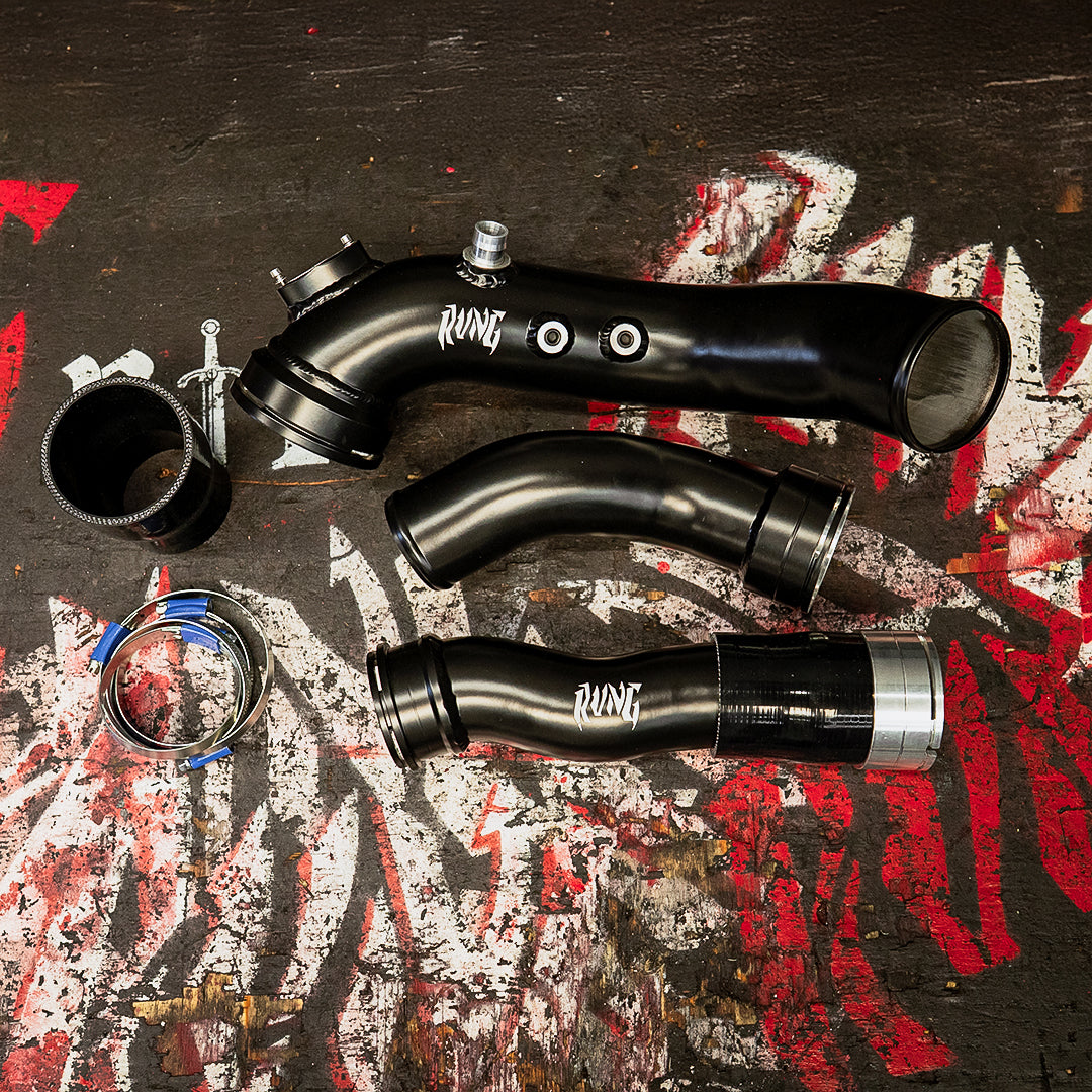 BMW M2 N55 Charge Boost Pipe Kit by RVNG displayed on a grunge background. Includes high-performance aluminum pipes and silicone couplers.